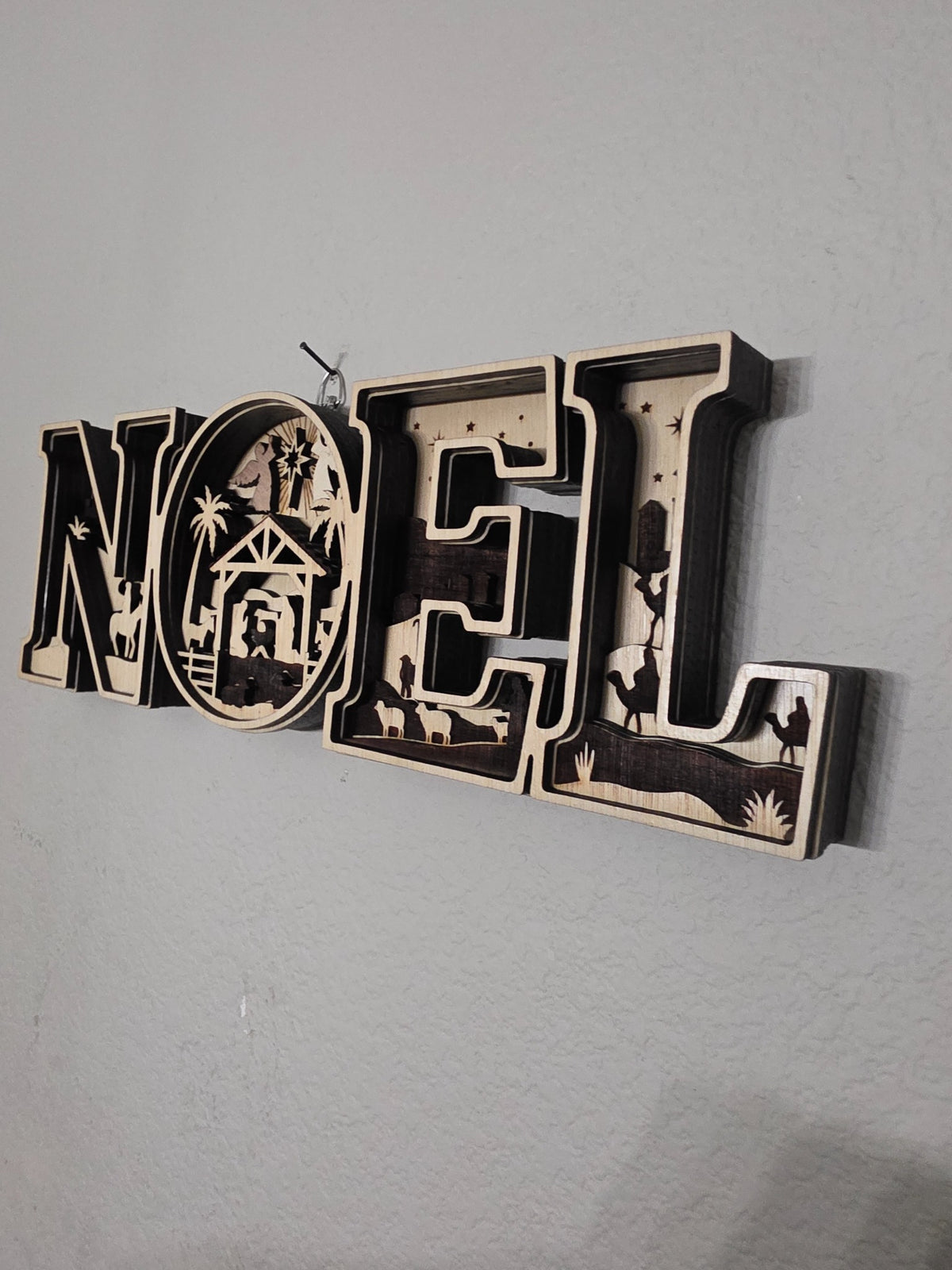 Side angle showing depth of NOEL nativity layered wood wall art